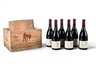 six bottles of wine in a wooden crate with a box of wine in the background