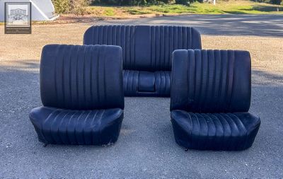 four black seats sitting in the middle of a parking lot