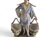 a figurine of a woman holding two baskets