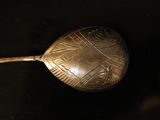 a silver spoon with a metal handle on a black surface