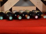 several bottles of wine are lined up on a red table cloth