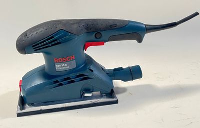 une ponceuse orbitale Bosch sur une surface blanche