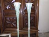 deux grands vases posés sur une table devant une armoire en bois