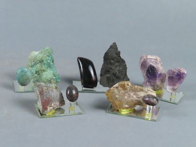 Plusieurs cristaux de différentes couleurs sont présentés sur des socles en acrylique transparent