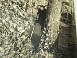 a black and white photo of a man standing in the woods