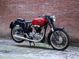 a red motorcycle parked in front of a brick wall