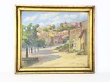 une peinture à l'huile représentant une rue avec des maisons et des arbres, dans un cadre doré