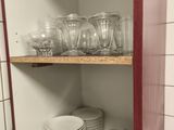 de nombreuses assiettes et verres sur les étagères de la cuisine