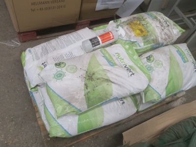 plusieurs sacs de riz posés sur une palette, à côté d'un carton