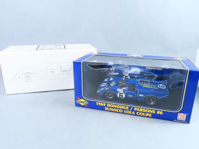 un camion jouet bleu dans une boîte, à côté d'une boîte blanche