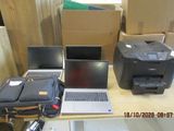 several laptops and a printer on a table in a room