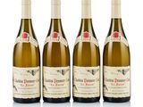 three bottles of white wine are lined up on a white surface