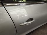 a door handle on a silver car with the door handle open