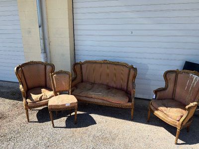 three chairs and a couch sitting in front of a white wall
