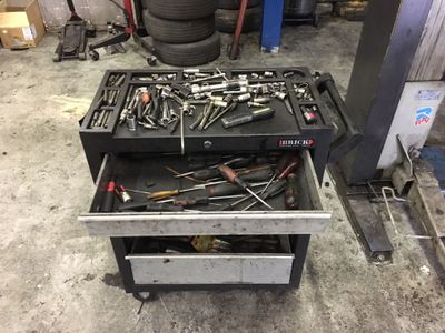 a drawer full of tools sitting in a garage