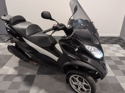 un scooter garé sur un sol à damier