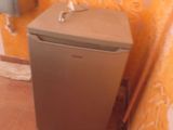 un petit réfrigérateur dans un coin d'une petite salle de bains