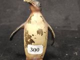 une petite figurine de pingouin munie d'une étiquette