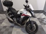 une moto blanche et noire garée sur un sol à damier