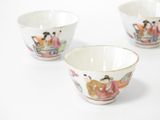 three small bowls with asian designs on them on a white surface