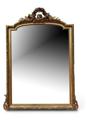 un miroir orné d'un cadre doré sur fond blanc