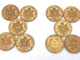 a close up of a number of gold coins on a white surface