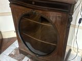 a wooden cabinet with a glass door and a lamp on top