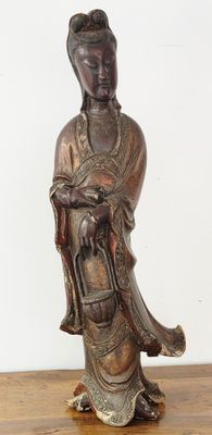 une statue antique en bronze représentant une femme tenant un panier