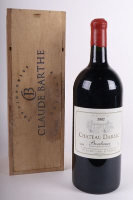 une bouteille de vin rouge devant une caisse en bois