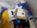 a pile of clothing and a box on a bed