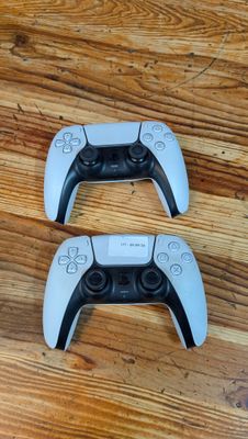 deux manettes de jeux vidéo posées sur un parquet