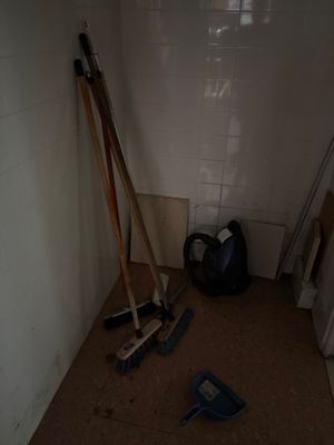 une photo d'une pièce avec un balai, des balais et un sac