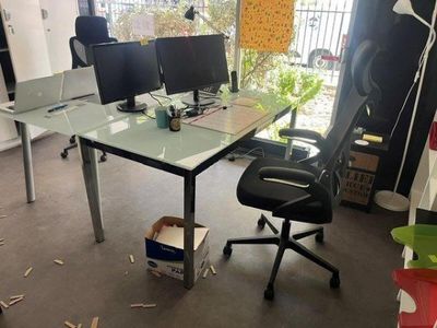 a desk with two monitors and a chair in a room