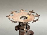 a metal candle holder that has a flower design on it