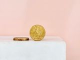 a gold coin sitting on top of a white box