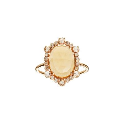 une bague en or sertie d'une pierre ovale entourée de petits diamants blancs