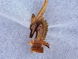 une broche en forme de cheval en or posée sur un tissu blanc