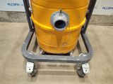 a large yellow drum sitting on a dolly in a room