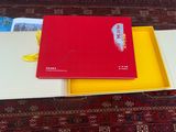 un livre rouge posé sur une boîte jaune