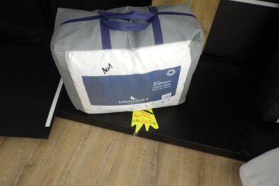 un sac blanc muni d'une poignée bleue posé sur une table noire