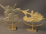 pair of brass sculptures of a sea horse and a shell on a stand