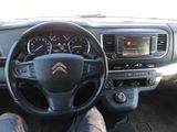 someone is sitting in the driver ' s seat of a car with their feet on the steering wheel