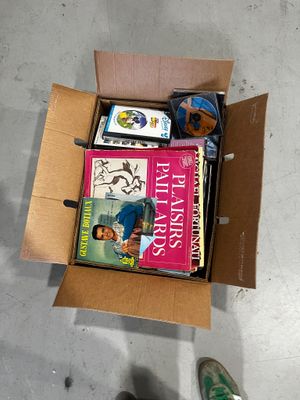 a cardboard box full of books on the floor