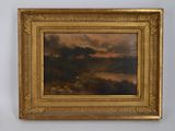une peinture à l'huile représentant un paysage avec des nuages, dans un cadre doré