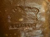 a close up of a brown vase with a crown on it