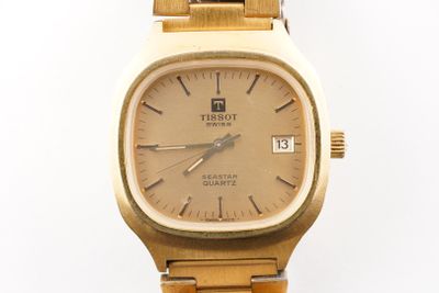 gros plan d'une montre-bracelet en or sur fond blanc