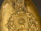 a gold bell with a bird on top of it