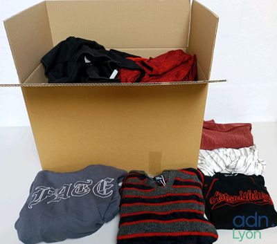 une boîte en carton remplie de vêtements et d'un pull