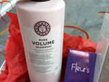 a person holding a bottle of liquid next to a box of hair products