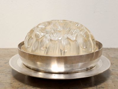 a silver plate with a clear glass dome on it